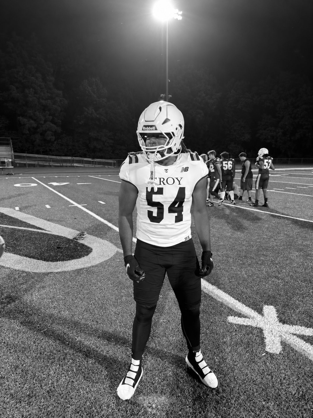 Black-and-white editorial portrait of Joseph Fleuriot III in his number 54 Troy uniform under the stadium lights